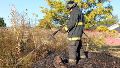 Un bombero apagando pastos quemados.