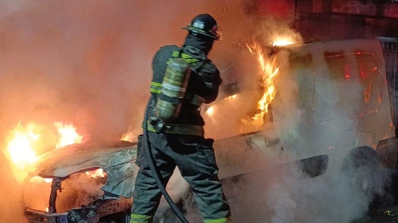 Bomberos trabajando sobre el vehículo en llamas.