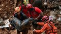 Los bomberos cargan un cadáver encontrado entre los escombros tras un deslizamiento de tierra causado por las fuertes lluvias en el Barrio Parque Jardim Burnier, en Juiz de Fora, Estado de Minas Gerais, Brasil.