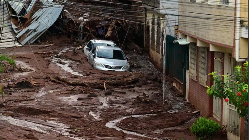 Vehículos parcialmente cubiertos de barro tras un deslizamiento de tierra provocado por fuertes lluvias en el barrio Paineiras, en Juiz de Fora, Minas Gerais.