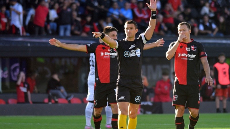 El juez Zunino levanta la mano y marca la posición adelantada de Mazzanti: atrás, se quejan Cóccaro y Regiardo.