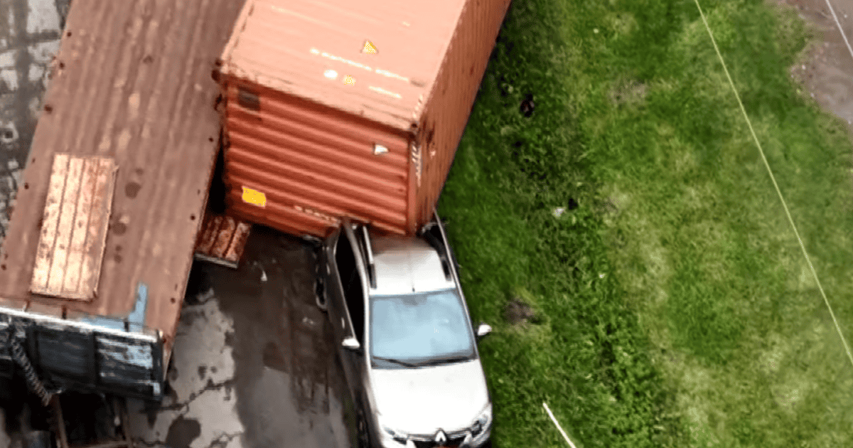 Contenedor caído sobre un auto en el camino viejo a Soldini