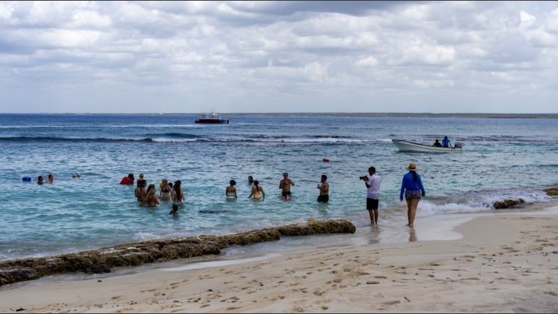 Visitantes disfrutan de las cálidas aguas turquesas que bañan las playas de Isla Catalina.