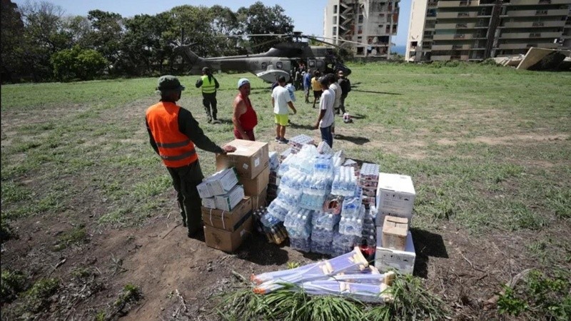 Un grupo de voluntarios descarga ayuda humanitaria de un helicóptero en La Guaira (EFE).