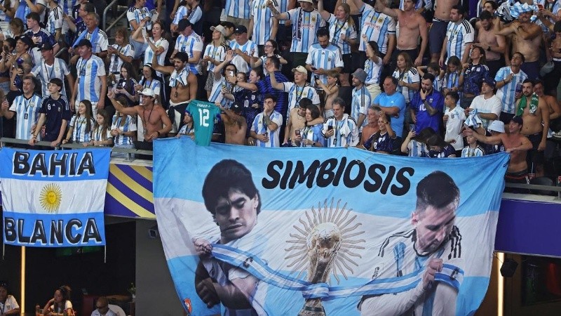 La hinchada argentina y una bandera con Maradona y Messi (EFE)