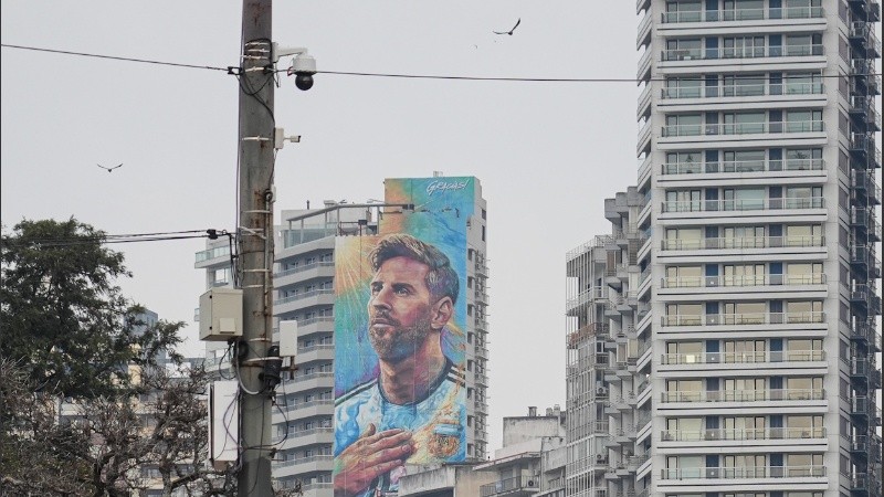 Foto de archivo del mural de Messi frente al río y atrás, un cielo gris.