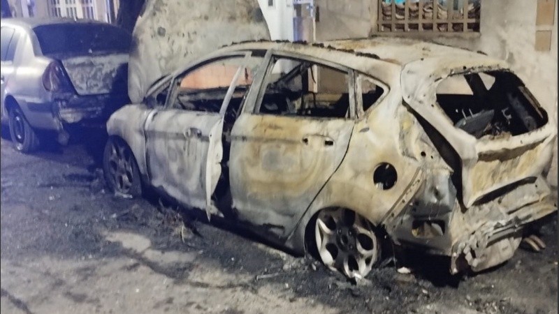 Los dos autos alcanzados por el fuego y el frente de la casa afectado.