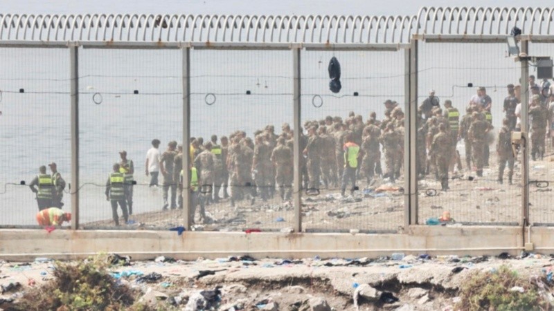 Ceuta, 01/08/2026.- Fuerzas auxiliares de Marruecos impiden la llegada al espigón de la playa del Tarajal que separa Ceuta de Marruecos, mientras se realiza la colocación de una boya flotante para marcar el límite entre la playa del Tarajal de Ceuta y Marruecos, tras la entrada masiva de personas en los últimos días. EFE/Reduan