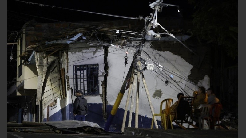 Personas esperan frente a una casa afectada luego de un terremoto de magnitud 7,4 este lunes, en Pereira (Colombia).