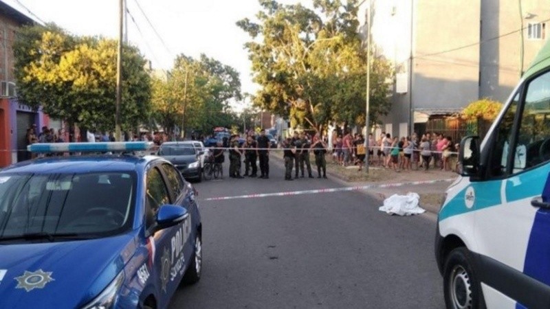 La mortaja de Carlini, sobre el cordón, siendo observada por vecinos.