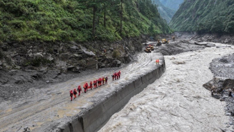 Bomberos realizan la búsqueda y rescate de desaparecidos en una zona afectada por los deslaves en Nepal.
