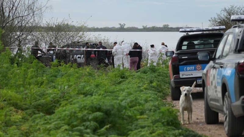 Los peritos forenses en el Corsa incendiado.