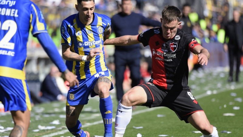 Di María y Regiardo disputan la pelota en el clásico del domingo pasado en Arroyito. (Fotobaires)