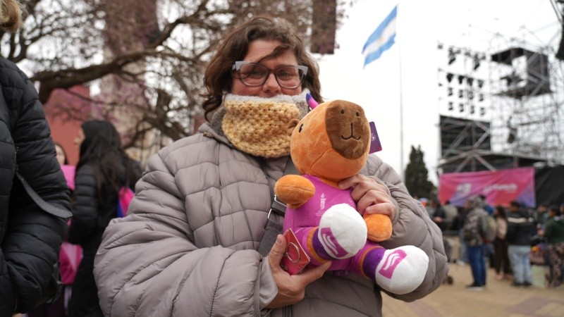 Una mujer sostiene un peluche de Capi, la mascota oficial de la competencia.