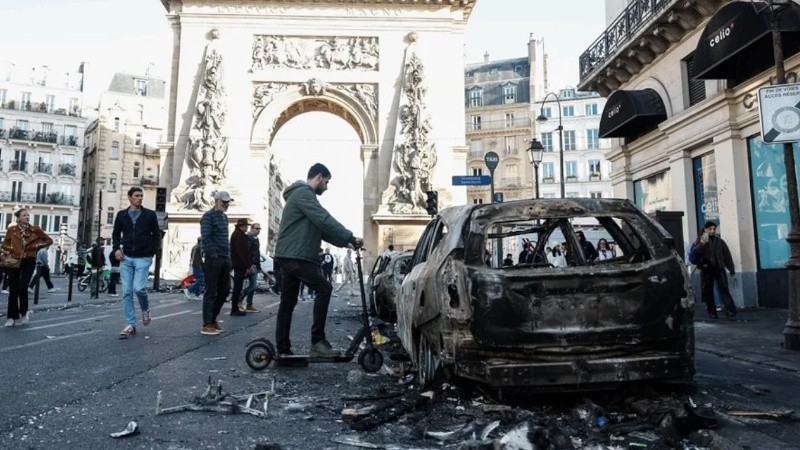La imagen de un coche calcinado tras los enfrentamientos entre la policía antidisturbios y los manifestantes en París (EFE)