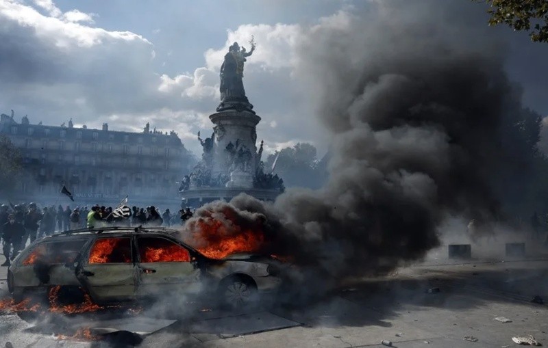 &nbsp;Un automóvil arde en la plaza de la República mientras estallan enfrentamientos entre manifestantes y la policía (EFE)