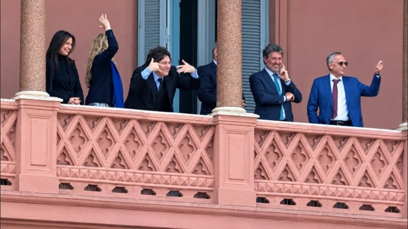 Javier Milei en el balcón de Cada Rosada, junto a parte del Gabinete, haciendo el popular gesto de 