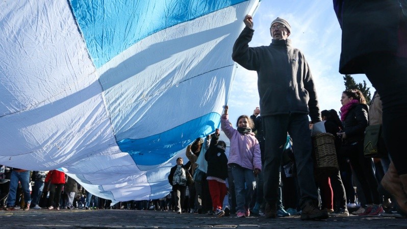 La gran bandera celeste y blanca es llevada por personas de todo el país durante el acto del Día de la bandera el 20 de junio. (Alan Monzón)